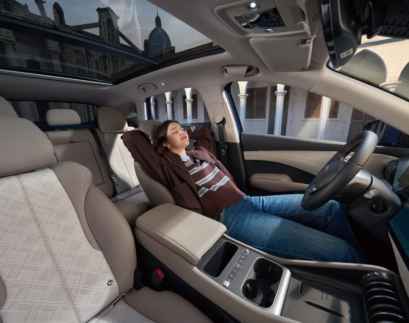 Egy fiatal nő kényelmesen hátradől a BYD ATTO 3 EVO ülésében
